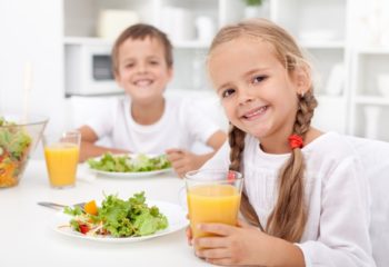 Kids eating a healthy meal in the kitchen