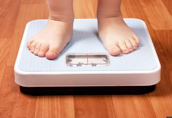 Closeup view of scales on a floor and kids feet; Shutterstock ID 75942880; PO: The Huffington Post; Job: The Huffington Post; Client: The Huffington Post; Other: The Huffington Post