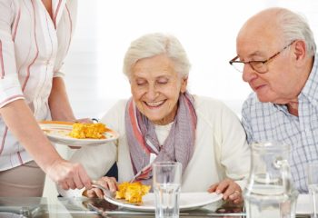 Senior citizens couple eating lunch at nursing home