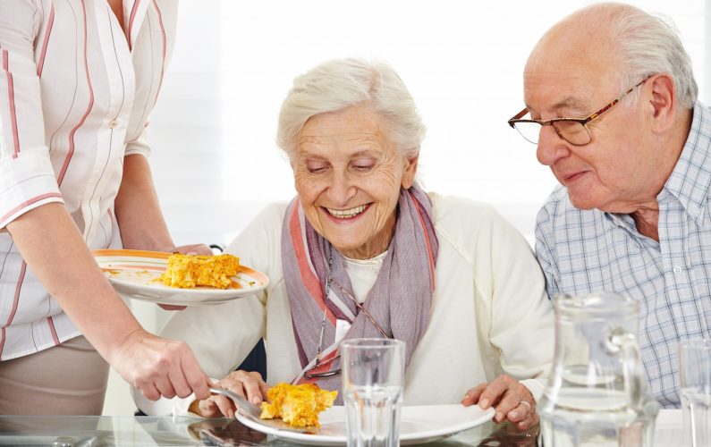 Senior citizens couple eating lunch at nursing home